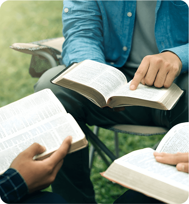 Group reads the bible together outside in lawn chairs