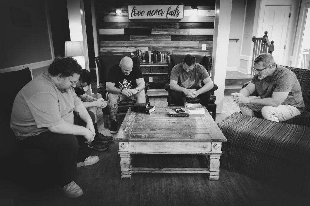 HopeQuest Group of men engage in prayer together